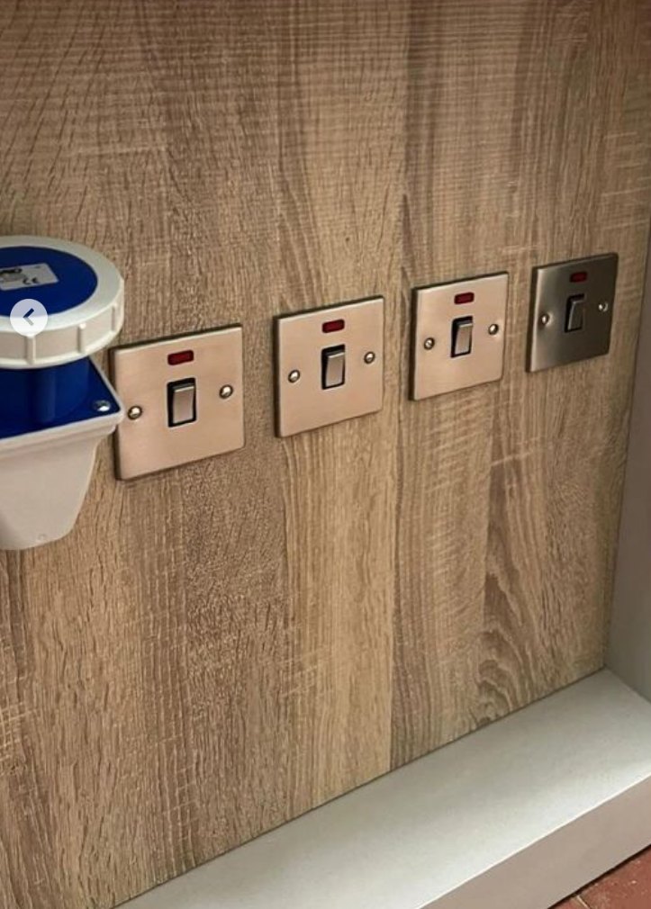 A row of switched sockets on a wood panel