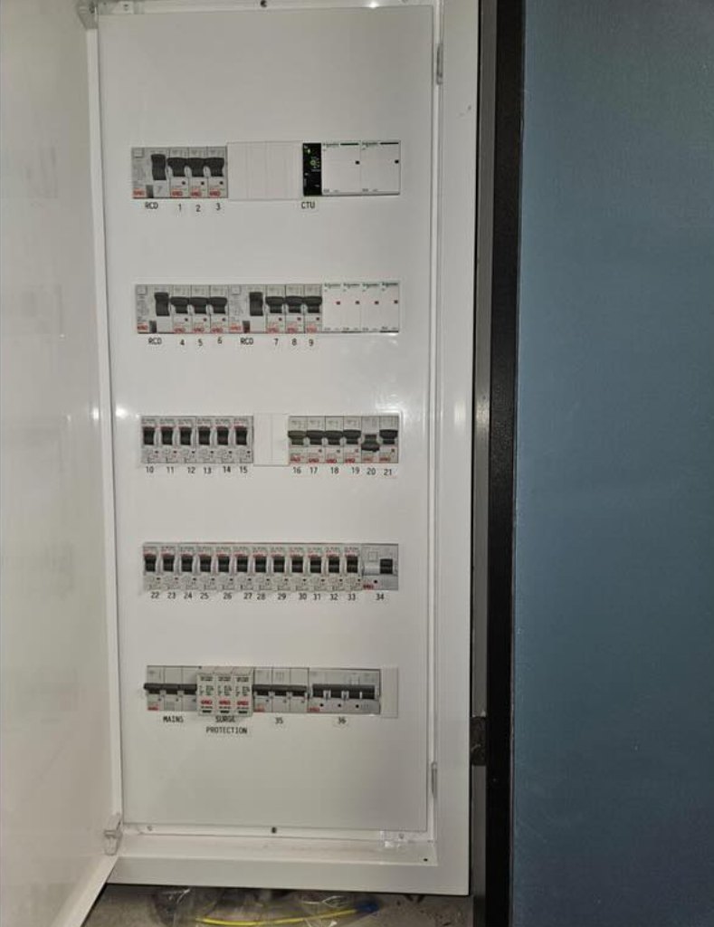An open distribution board with labelled breakers
