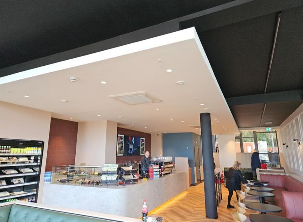A cafe counter and seating under recessed lights