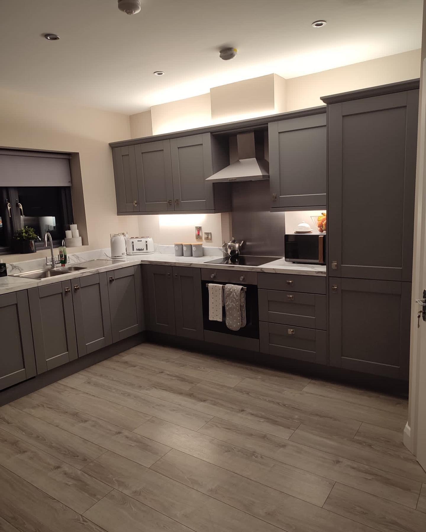 A grey fitted kitchen with under-cabinet lights