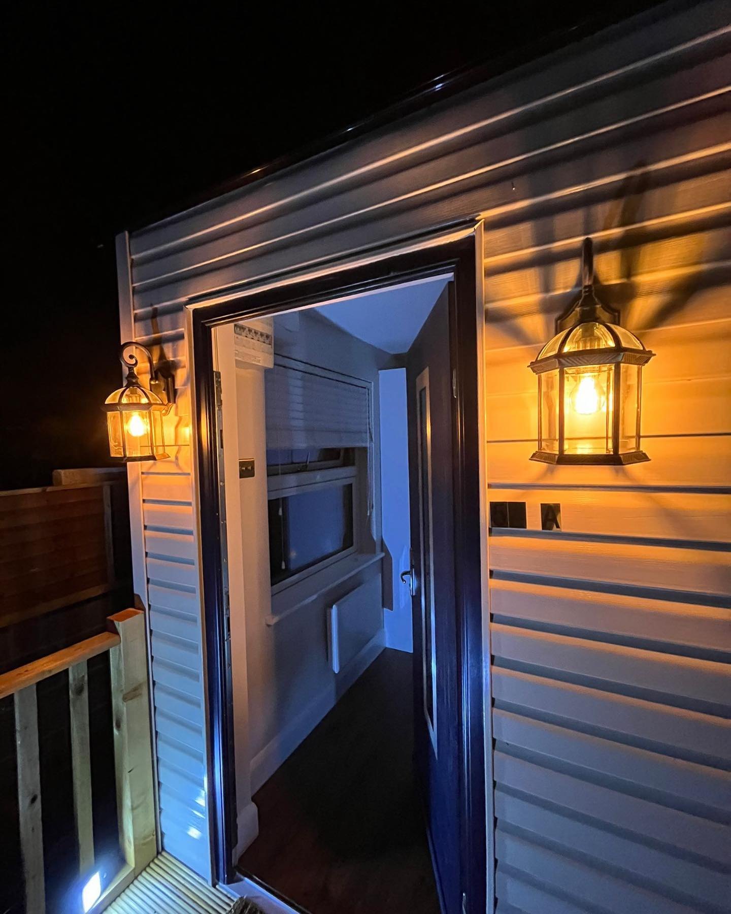 Lantern wall lights beside a doorway at night