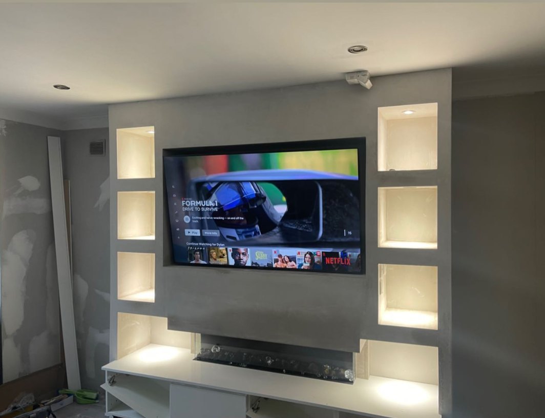 A media wall with a TV and lit shelf recesses